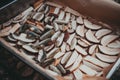 Closeup of a baking tray full of sliced mushrooms ready for drying.