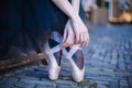 Closeup of ballerina`s feet in pointe on street. Strong fit ballerina`s legs