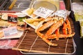 Closeup barbecue king crab legs and scallop on bamboo grill with Japanese name and price labels