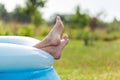 Closeup of bare feet sprinkled water, sticking out of an inflatable pool in nature. Child staying cool in the summer heat Royalty Free Stock Photo