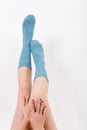 Closeup of the bare legs of a young woman wearing blue socks with his feet. Isolated on white background. Studio lighting Royalty Free Stock Photo