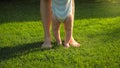 Closeup of barefoot baby boy and mother standing on fresh green grass at park. Concept of healthy lifestyle, child Royalty Free Stock Photo