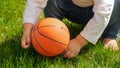 Closeup of barefoot baby boy playing with ball on green grass lawn. Kids outdoors, children in nature, baby playing outside Royalty Free Stock Photo