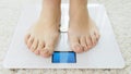 Closeup of barefoot woman using digital scales and checking her weight. Concept of dieting, loosing weight and healthy Royalty Free Stock Photo