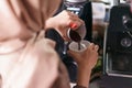 Closeup barista pour coffee into a cup.