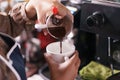 Closeup barista pour coffee into a cup.