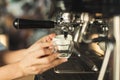 Closeup of barmen hand brewing espresso in professional coffee machine