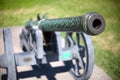 Barrel of old vintage copper cannon on wheels and carriages with a blurred background