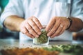 closeup of a bartenders hands muddling herbs in a glass