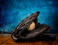 Closeup of a baseball, bat and a mitt on a wooden table against a blue background Royalty Free Stock Photo