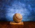 Closeup of a baseball on a marble coaster on the table against a blue background Royalty Free Stock Photo