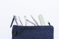 Closeup basic nail tool kit in blue bag isolate on white background