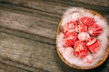 Closeup basket with Easter red eggs with folk white pattern lay on feather in the right side of rustic wood table. Ukrainian tradi