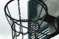 Closeup of a basketball hoop with chain net under the sunlight with a blurry background Royalty Free Stock Photo