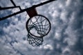 Closeup of a basketball hoop seen from below with a cloudy sky as background Royalty Free Stock Photo