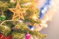 Closeup bauble hanging from a decorated Christmas tree on blurred background