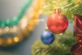 Closeup bauble hanging from a decorated Christmas tree on blurred background