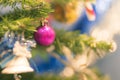 Closeup bauble hanging from a decorated Christmas tree on blurred background