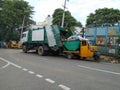 Closeup of BBMP garbage collecting lorry and auto parking on roadside Royalty Free Stock Photo