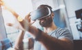 Closeup of bearded young man wearing virtual reality goggles in modern coworking studio. Smartphone using with VR Royalty Free Stock Photo