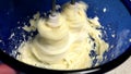 beating butter in blue bowl with mixer