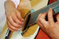 Closeup beautiful acoustic guitar being played by hispanic woman sitting down, musician concept Royalty Free Stock Photo