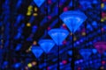 Closeup of beautiful colorful neon diamond gears hanging on ropes in a museum