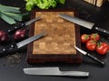 Closeup of a beautiful cutting board and a lot of knives Royalty Free Stock Photo