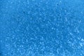 Closeup of beautiful dynamic water surface with falling droplets in blue color. Royalty Free Stock Photo