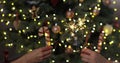 Closeup of beautiful female and man hands holding two stick of holiday sparkler burning isolated at blurry Christmas Royalty Free Stock Photo