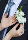Floral corsage ready to be pined at blue suit of man