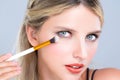 Closeup beautiful girl with flawless applying alluring eye shadow makeup. Royalty Free Stock Photo