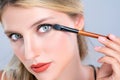 Closeup beautiful girl with flawless applying alluring eye shadow makeup. Royalty Free Stock Photo