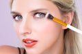 Closeup beautiful girl with flawless applying alluring eye shadow makeup. Royalty Free Stock Photo