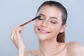 Closeup beautiful girl with flawless applying glamorous eye shadow makeup. Royalty Free Stock Photo