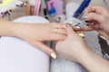 Closeup of beautiful hands applying transparent nail polish in beauty salon. Manicurist hand painting client`s nails Royalty Free Stock Photo