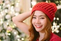 Closeup of beautiful natural looking young smiling Asian woman wearing knitted sweater and winter hat taking selfie in room house Royalty Free Stock Photo