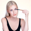 Closeup beautiful personable girl with flawless applying eye shadow makeup. Royalty Free Stock Photo