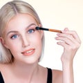 Closeup beautiful personable girl with flawless applying eye shadow makeup. Royalty Free Stock Photo