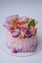 Closeup of a beautiful pink color birthday cake decorated with macarons and flowers Royalty Free Stock Photo