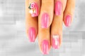 Closeup of beautiful pink nail design at female fingers on brigh