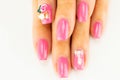 Closeup of beautiful pink nail design at female fingers on white Royalty Free Stock Photo