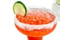 Closeup of a beautiful red cocktail in a glass with ice on a thin leg decorated with a slice of lime. Royalty Free Stock Photo