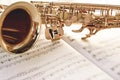 Closeup of a beautiful and shiny golden saxophone lying on music notes. Royalty Free Stock Photo