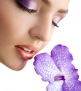 Closeup of beautiful tender female face with violet orchid