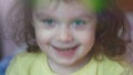 Closeup of a beautiful toddler girl 3-4 years with beautiful blue eyes smiling happily at camera