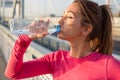 Closeup of a beautiful woman drinking water outside after training