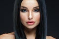 Closeup of beautiful woman face with beauty makeup and long brunette hair looking at camera isolated on black background Royalty Free Stock Photo