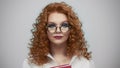 Woman in glasses standing in studio. Portrait of female student holding book Royalty Free Stock Photo