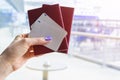 Closeup of beautiful woman hand holding passports and boarding pass tickets at airport terminal. Travel and holiday concept. Termi Royalty Free Stock Photo